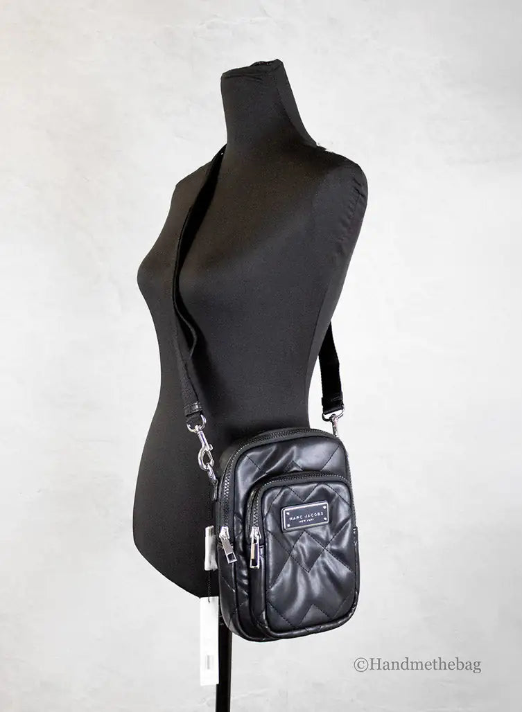 Black crossbody bag on a mannequin against a white background