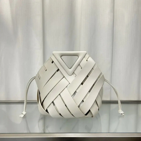 White woven bag with a geometric design on a reflective surface