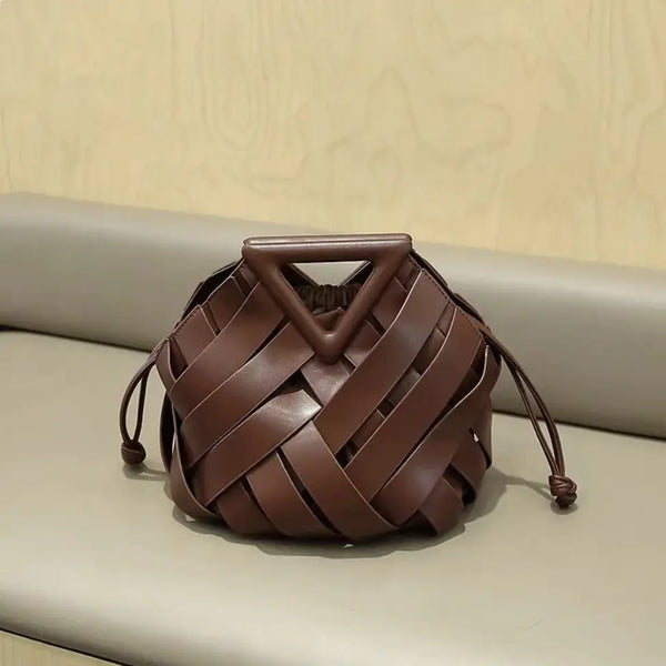 Brown woven handbag with a triangular handle on a beige surface